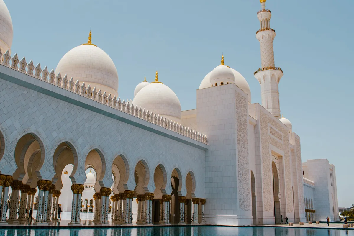 The Sheikh Zayed Grand Mosque facade and courtyard pools in bright sun