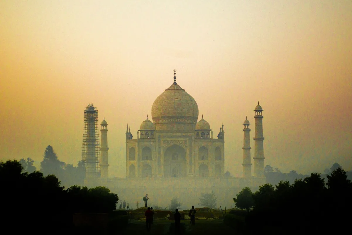 The Taj Mahal silhouetted in gold against the sunrise