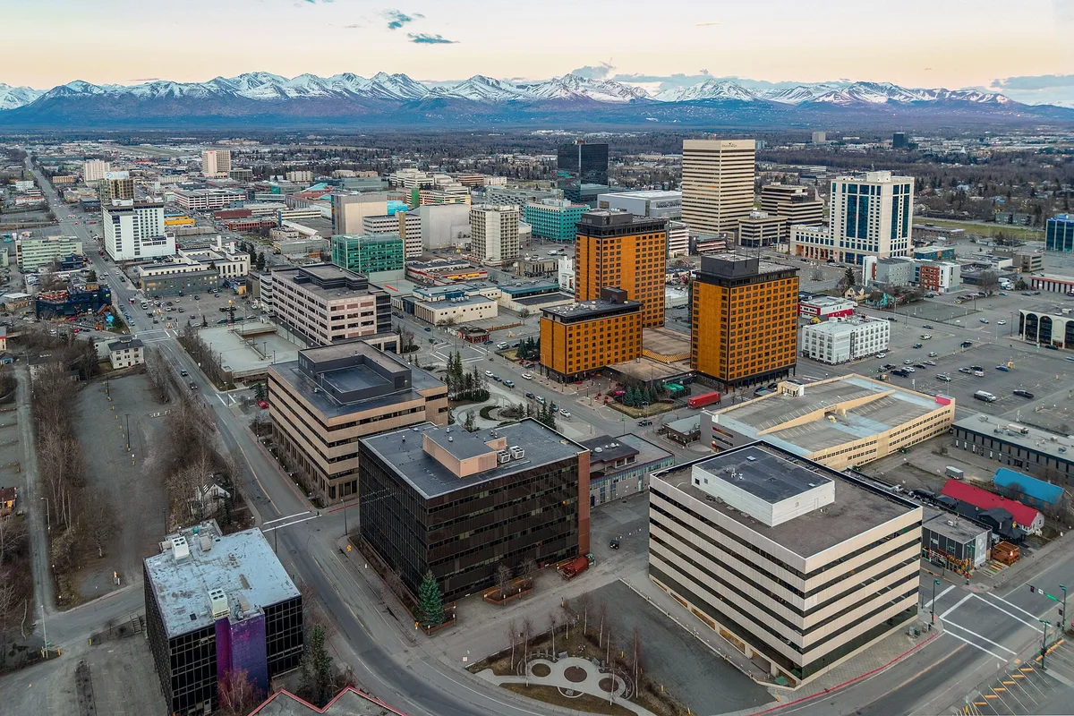 Aerial view of downtown Anchorage with the snow-capped Chugach Mountains behind the city