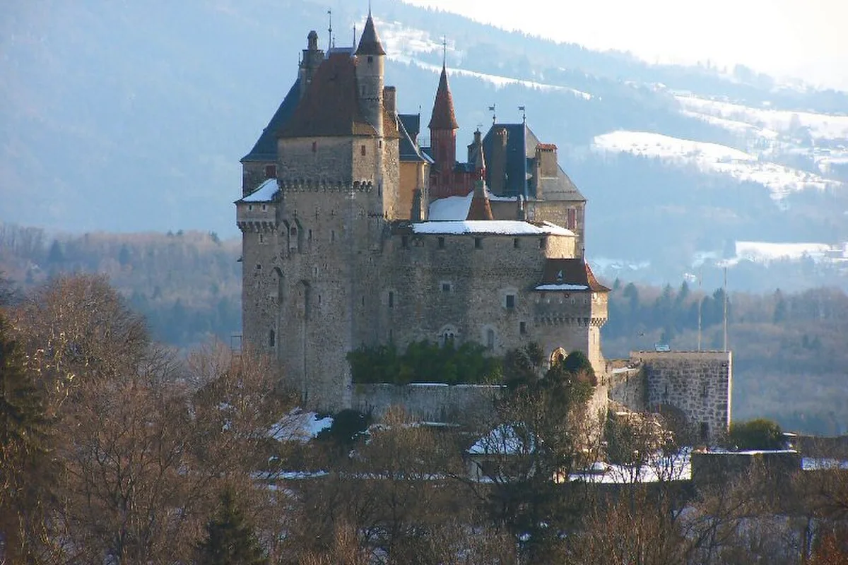 The turreted Château de Menthon-Saint-Bernard above Lake Annecy in winter