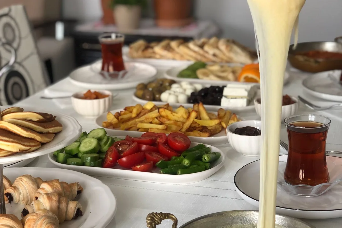 A Turkish breakfast spread with melted cheese, olives, eggs and tea