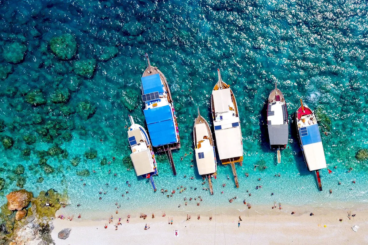 Tour boats anchored in the turquoise water off Suluada island