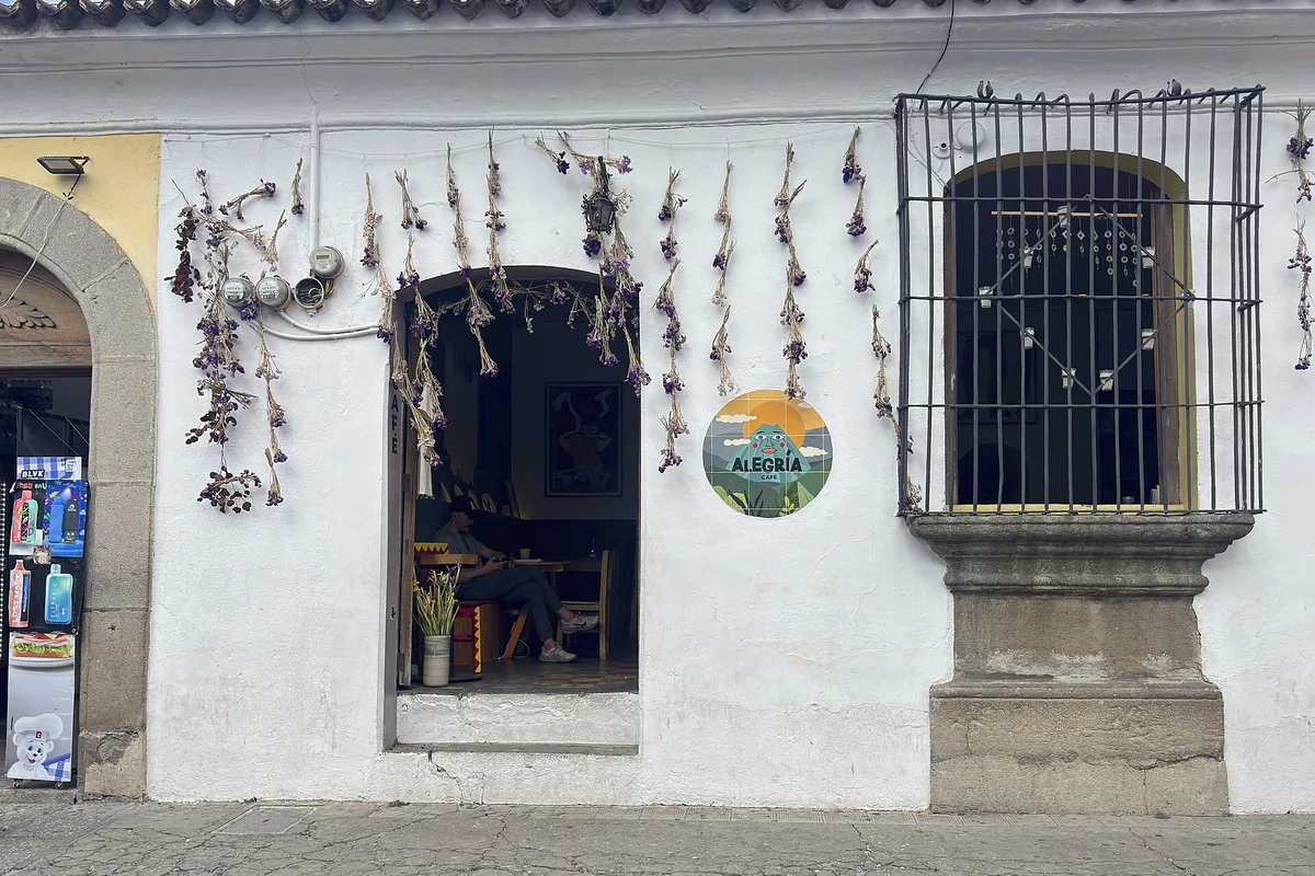 A whitewashed café front hung with dried flowers in Antigua Guatemala