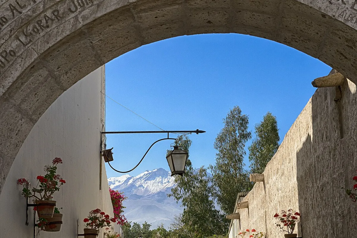 A snow-capped volcano framed by a sillar arch at the Yanahuara viewpoint
