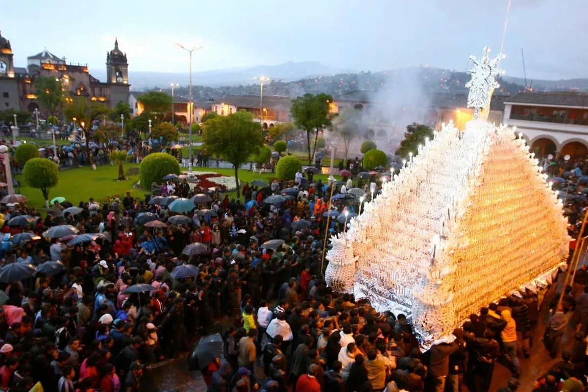 A Semana Santa procession carrying its anda through a packed Plaza Mayor in Ayacucho