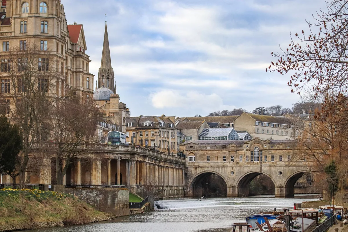 Pulteney Bridge and its weir on the River Avon in Bath, shops lining the bridge