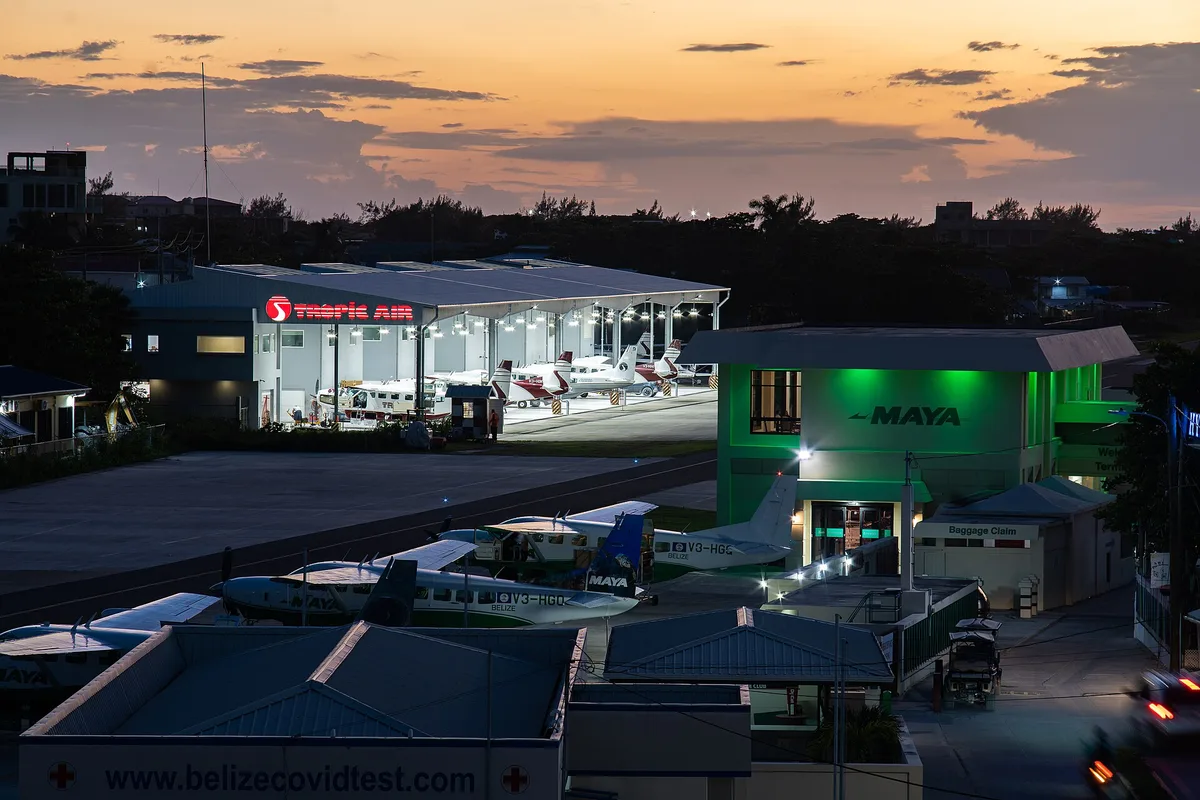 The Tropic Air and Maya Island Air terminals side by side at San Pedro's airstrip at dusk