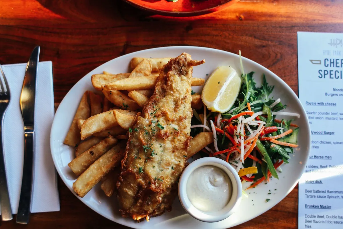 A plate of fish and chips with lemon, salad and tartare sauce, the Brighton seafront classic