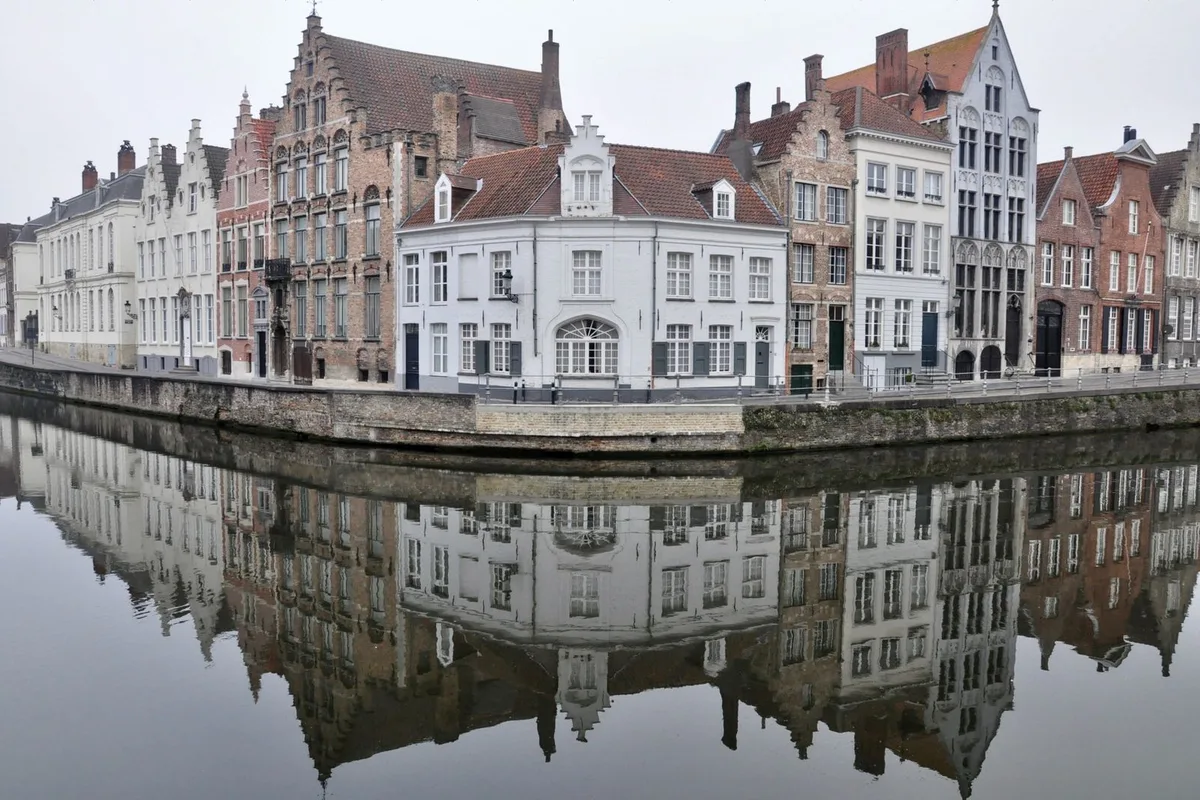 Canalside houses reflected in the water at Rozenhoedkaai in Bruges