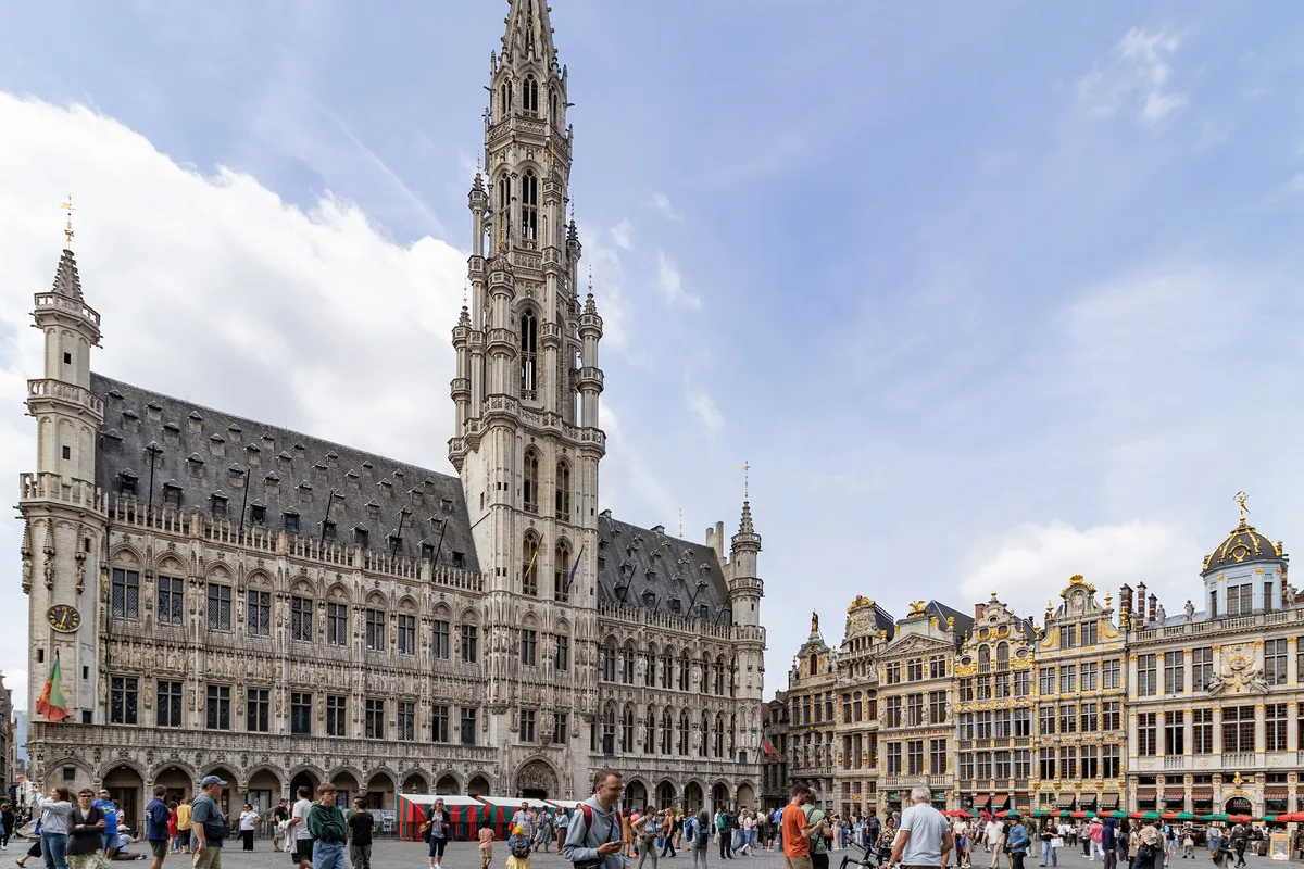 Travellers crossing the Grand-Place in front of the Town Hall and guildhalls