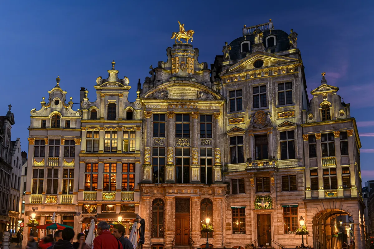 The Grand-Place guildhalls under a clear evening sky