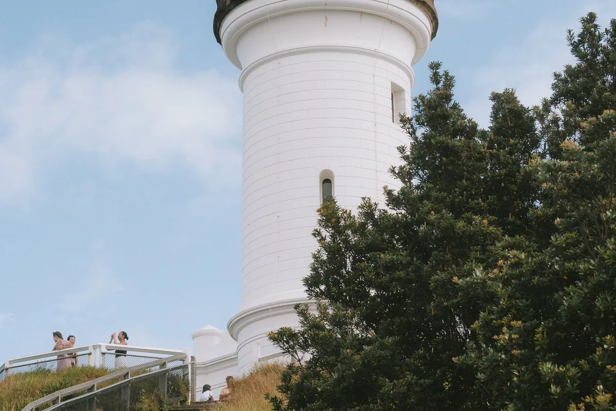 The white tower of Cape Byron Lighthouse above the walking track, Byron Bay