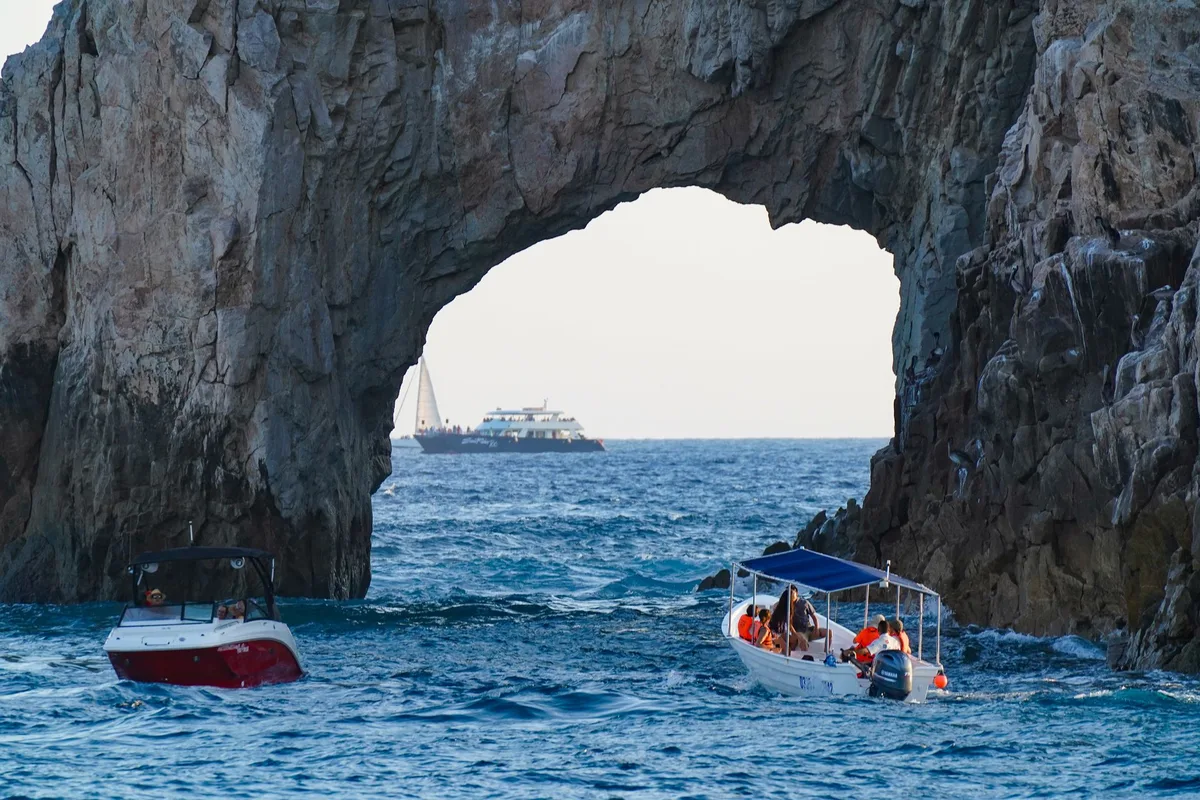 Tour boats passing under El Arco at Land's End