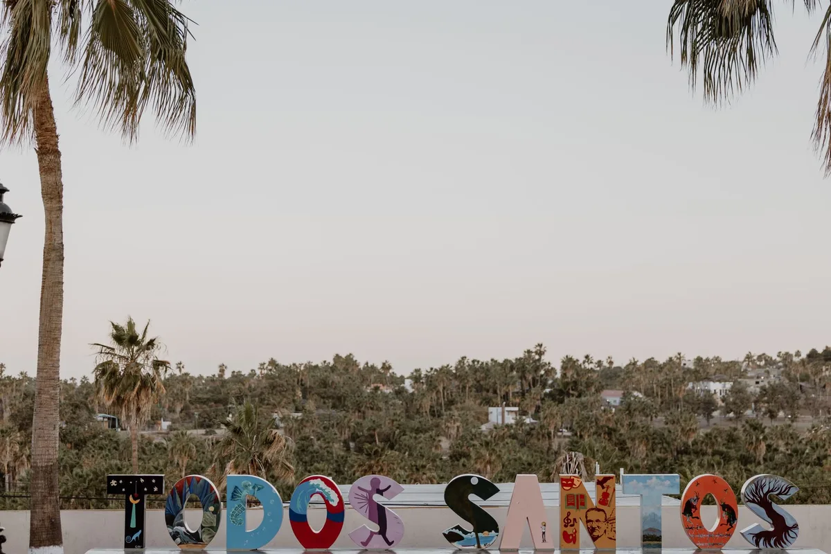 The colourful TODOS SANTOS letters at the town entrance, palms behind
