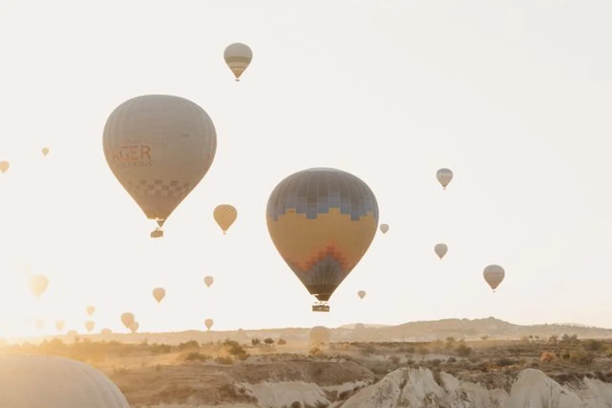 Hot air balloons at sunrise over the Göreme valleys, seen from a balloon basket