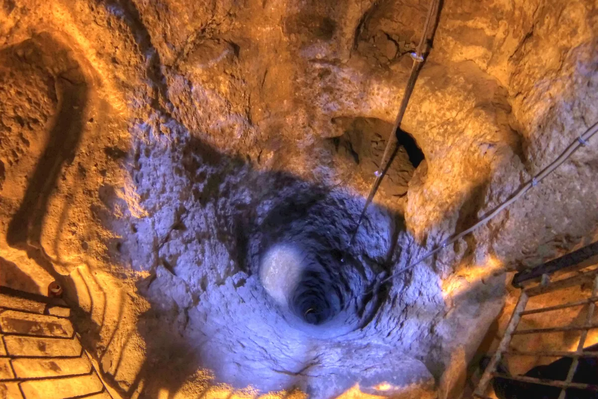 The ventilation shaft of Derinkuyu Underground City, dropping through the rock below the town