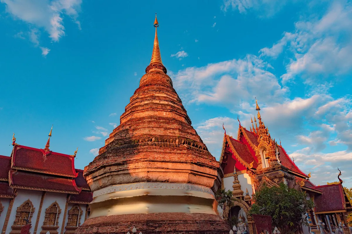 A gilded chedi with red temple roofs in Chiang Mai