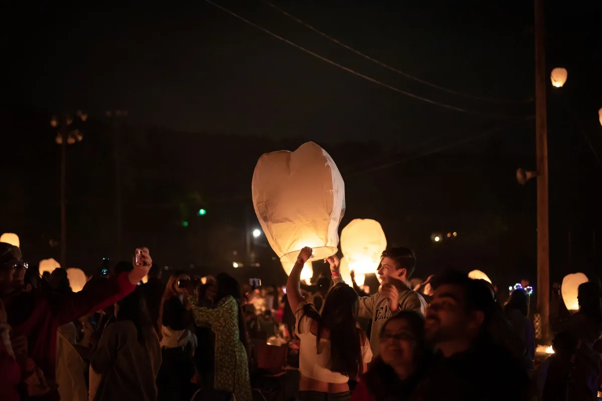 Crowds releasing lanterns into the night sky at the Yi Peng festival
