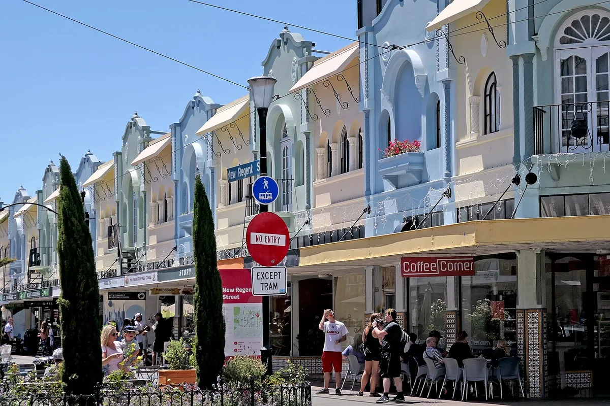 Pastel Spanish Mission buildings and cafes along New Regent Street