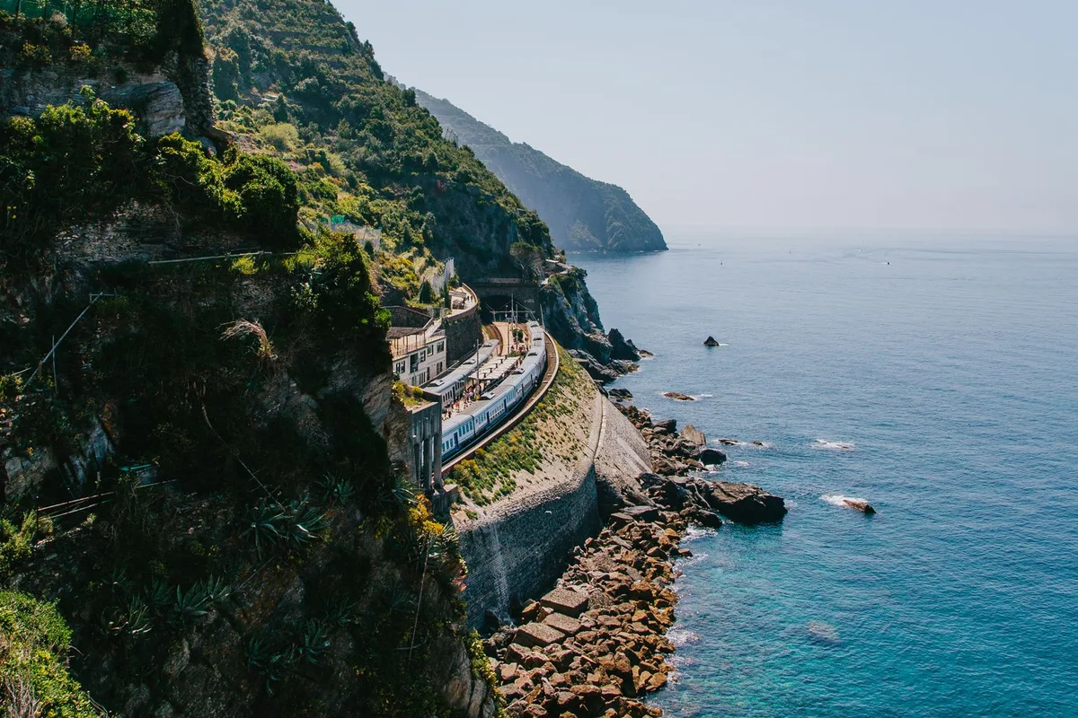 A train on the coastal line above the turquoise sea between the villages