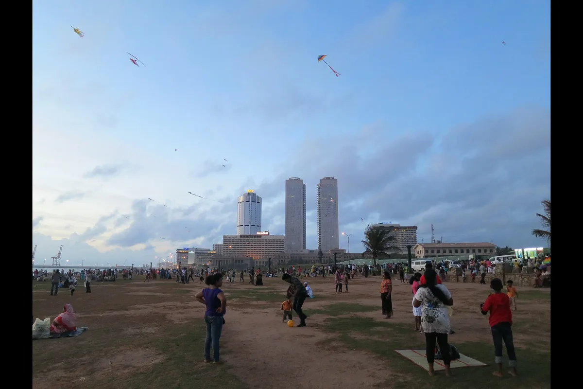 Sunday crowds and kites on Galle Face Green, with the World Trade Center towers behind