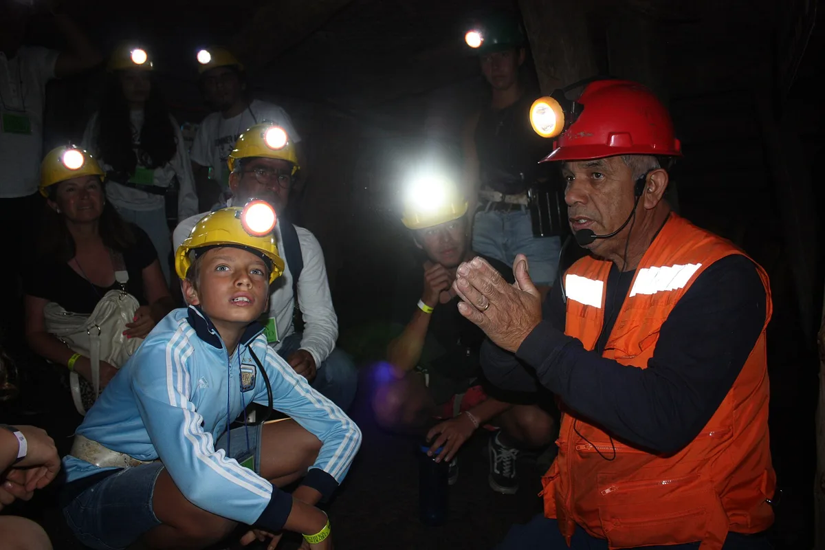 Visitors with helmet lamps inside the Chiflón del Diablo coal mine at Lota