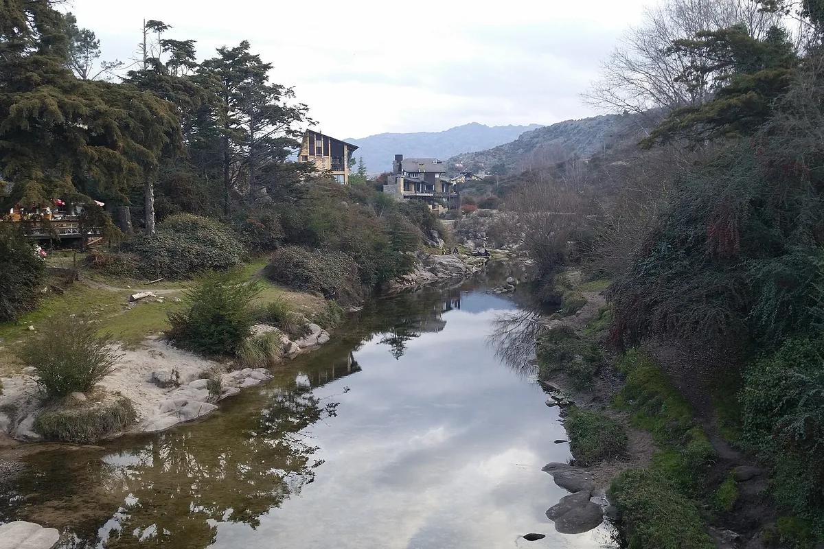 The stream running through La Cumbrecita, pines and village houses on its banks