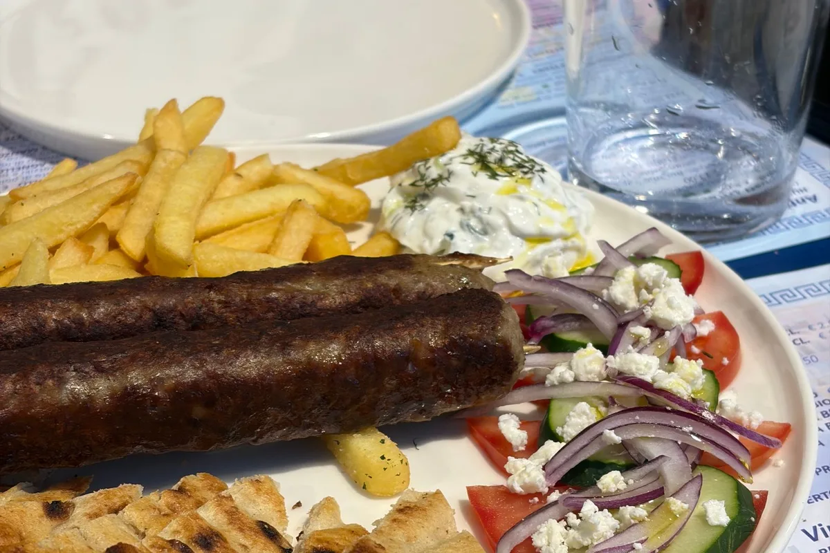 A taverna plate of souvlaki with pita, salad and fries