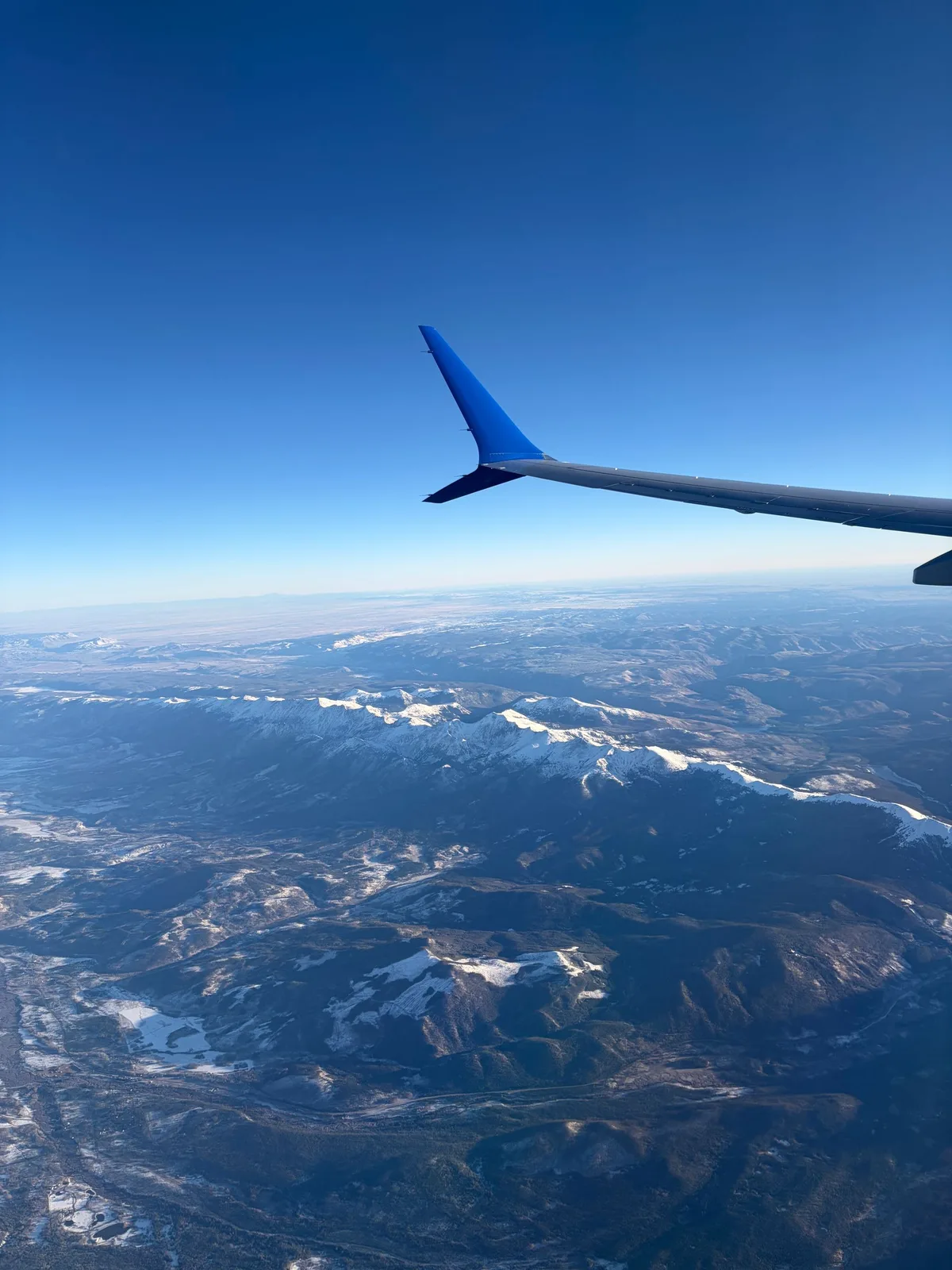 Snowy peaks under a United wing on the approach into Denver