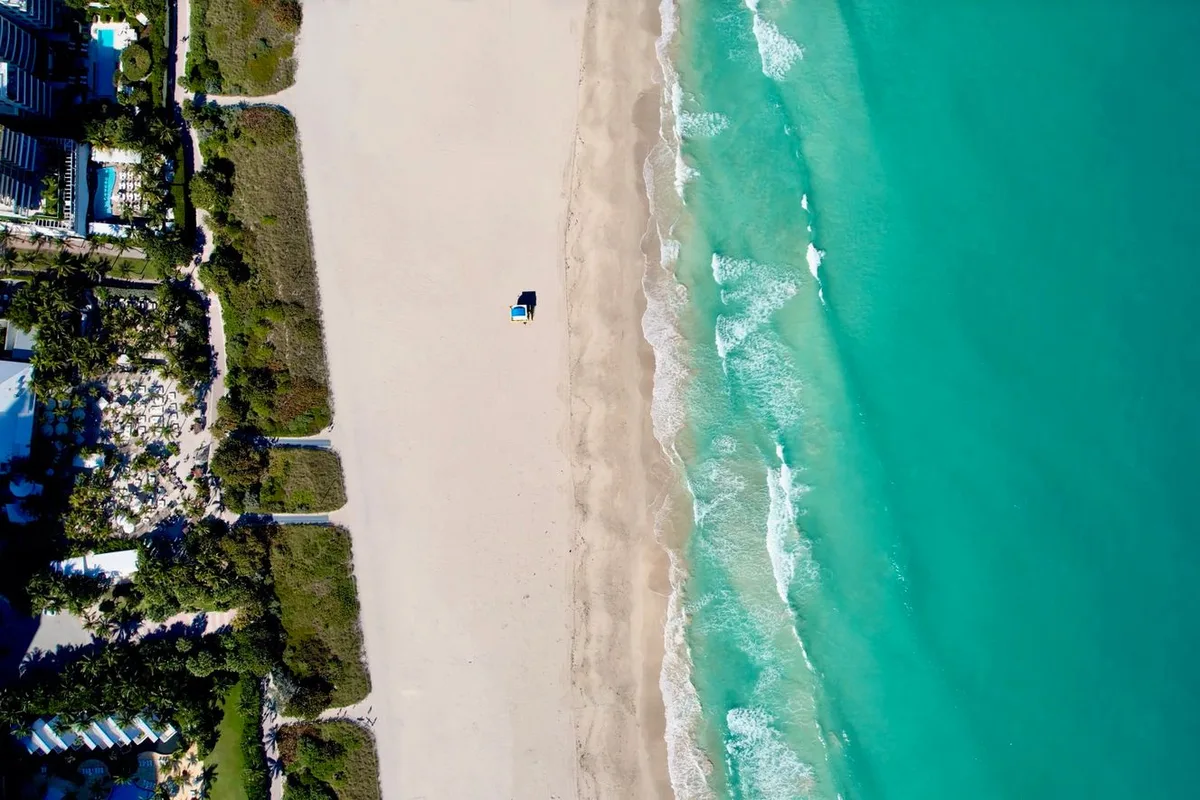 Emerald water over white sand along the Destin shoreline, seen from above