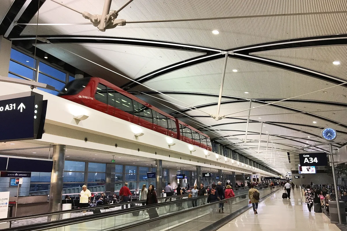 Inside the McNamara Terminal at Detroit Metro Airport, with the red ExpressTram passing overhead