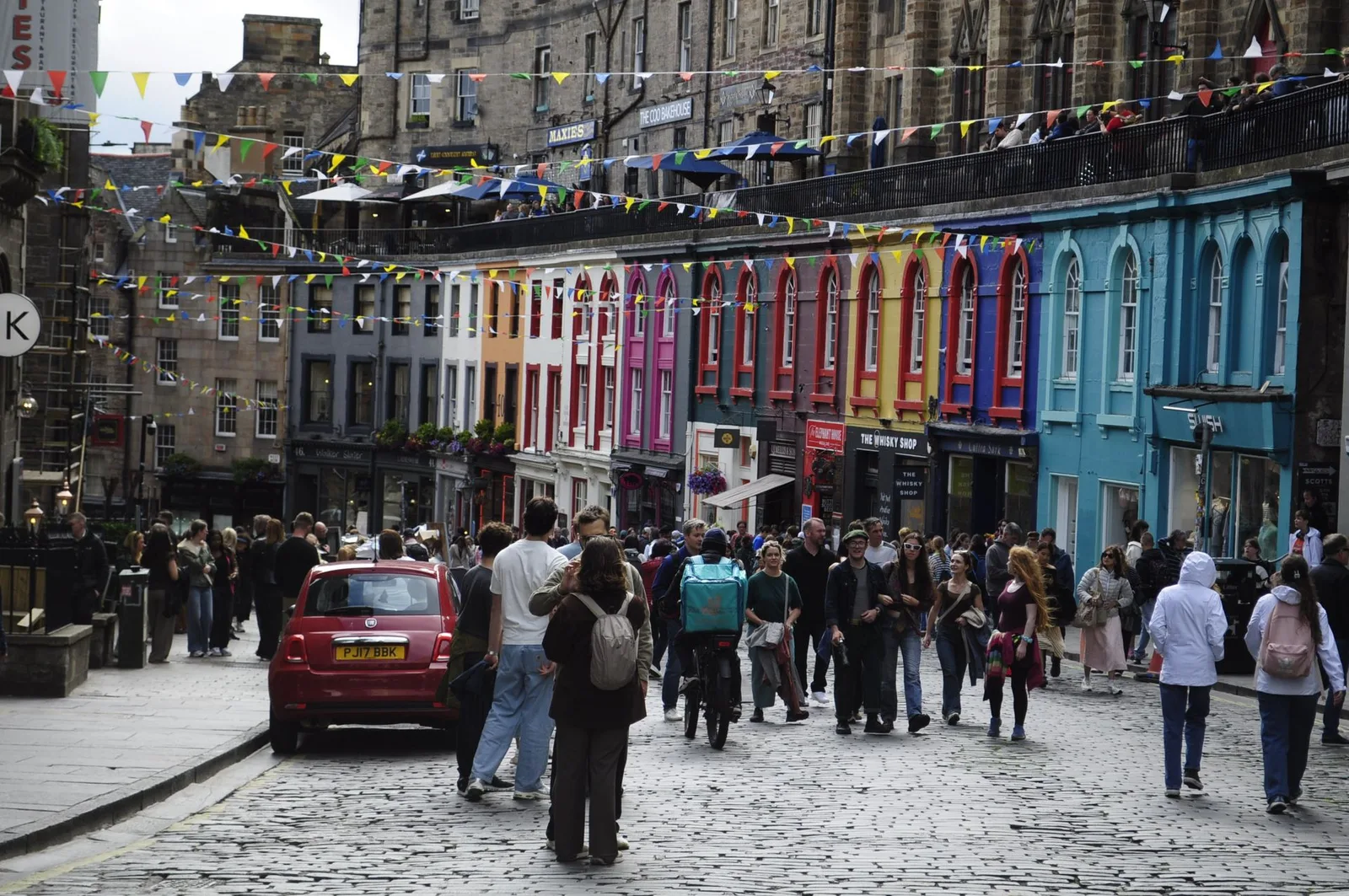 Victoria Street's colourful curved facades strung with bunting, crowds on the cobbles