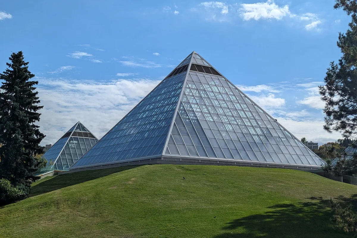 The Muttart Conservatory glass pyramids on their grassy hill in summer