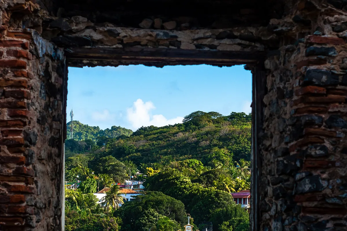 The Igreja Nossa Senhora dos Remédios church seen through a stone arch of the Forte dos Remédios