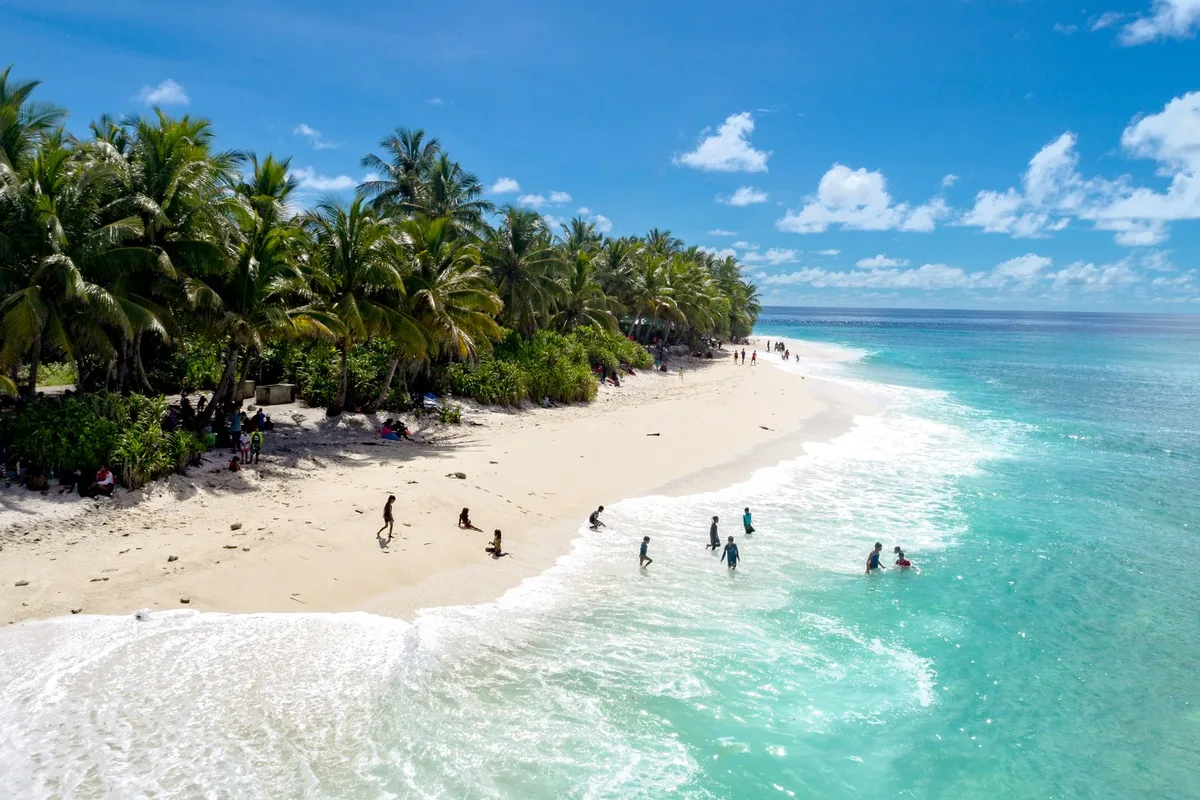 Dry-season surf over a palm-lined Fiji beach — the May to October Fiji