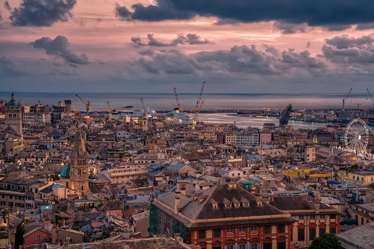 Genoa's old town and harbour under a pink dusk sky