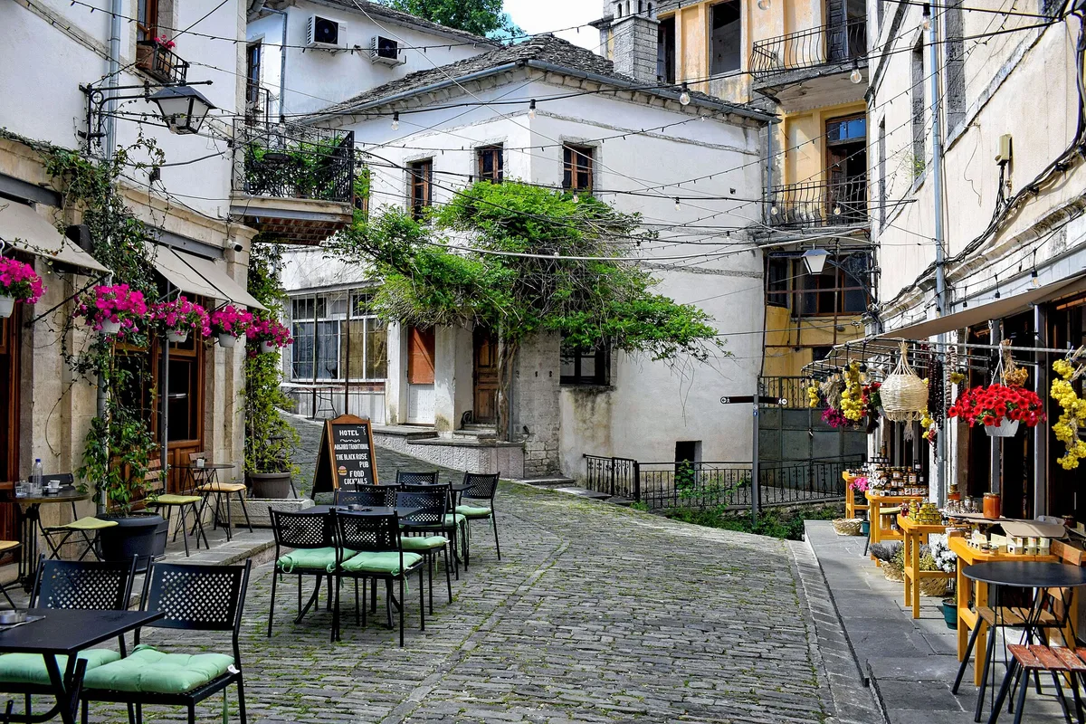 A cobbled lane of cafés in Gjirokaster's old town, below the castle