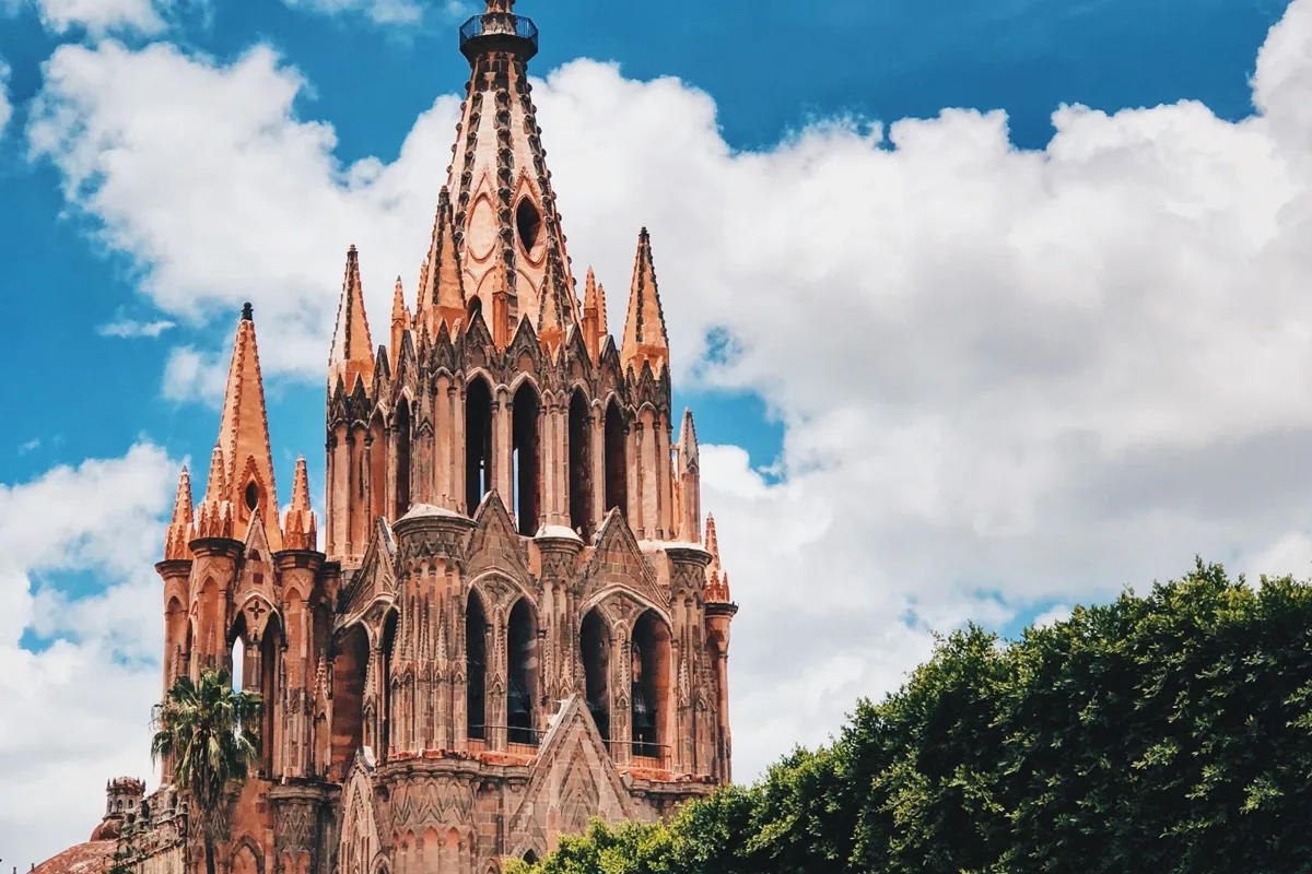 The pink stone Parroquia church in San Miguel de Allende against a blue sky