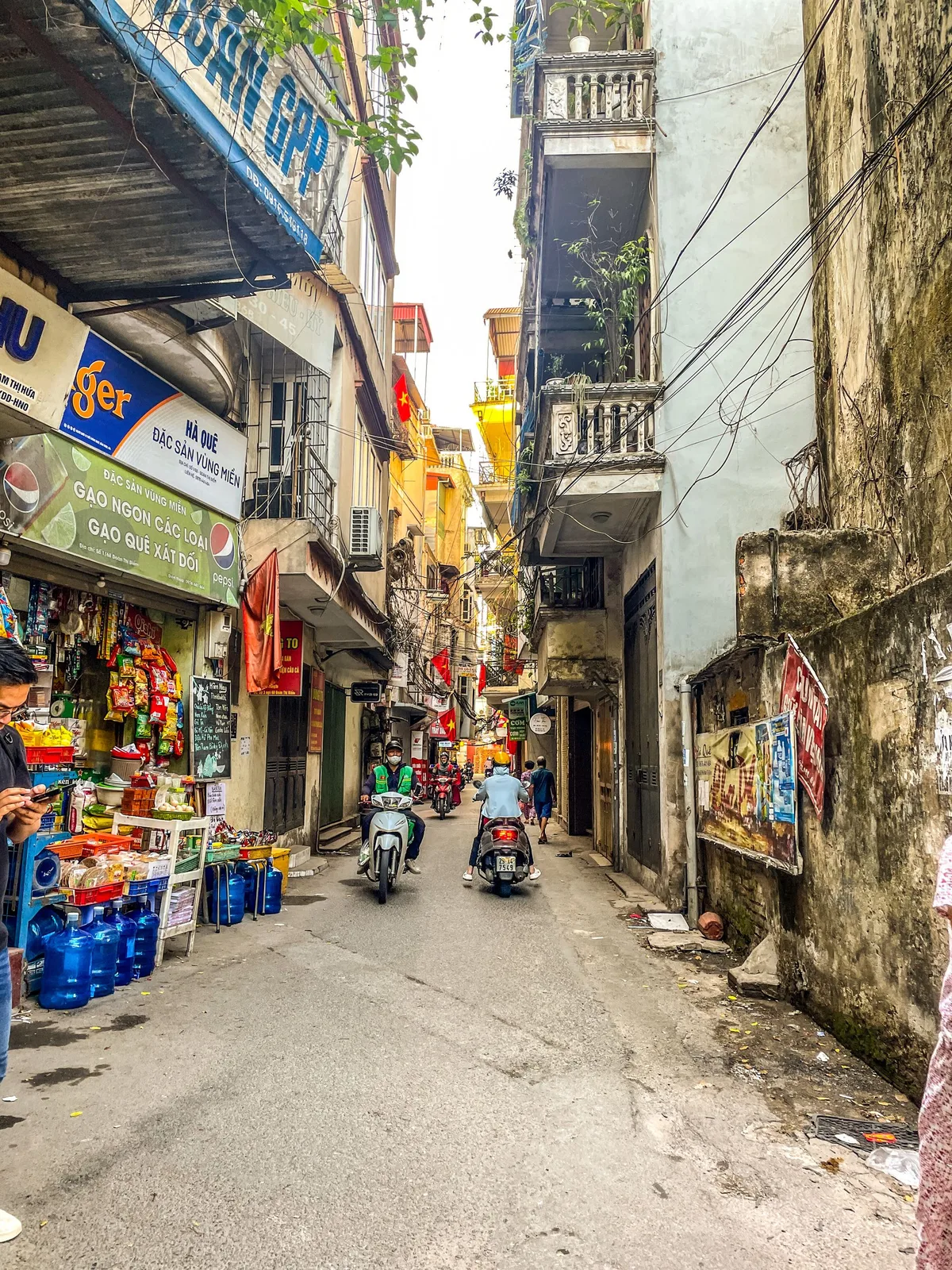 A narrow Old Quarter alley of tube houses and scooters