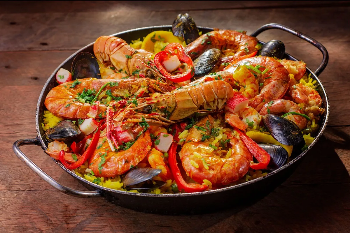 A seafood paella with prawns, mussels and peppers, served in the pan