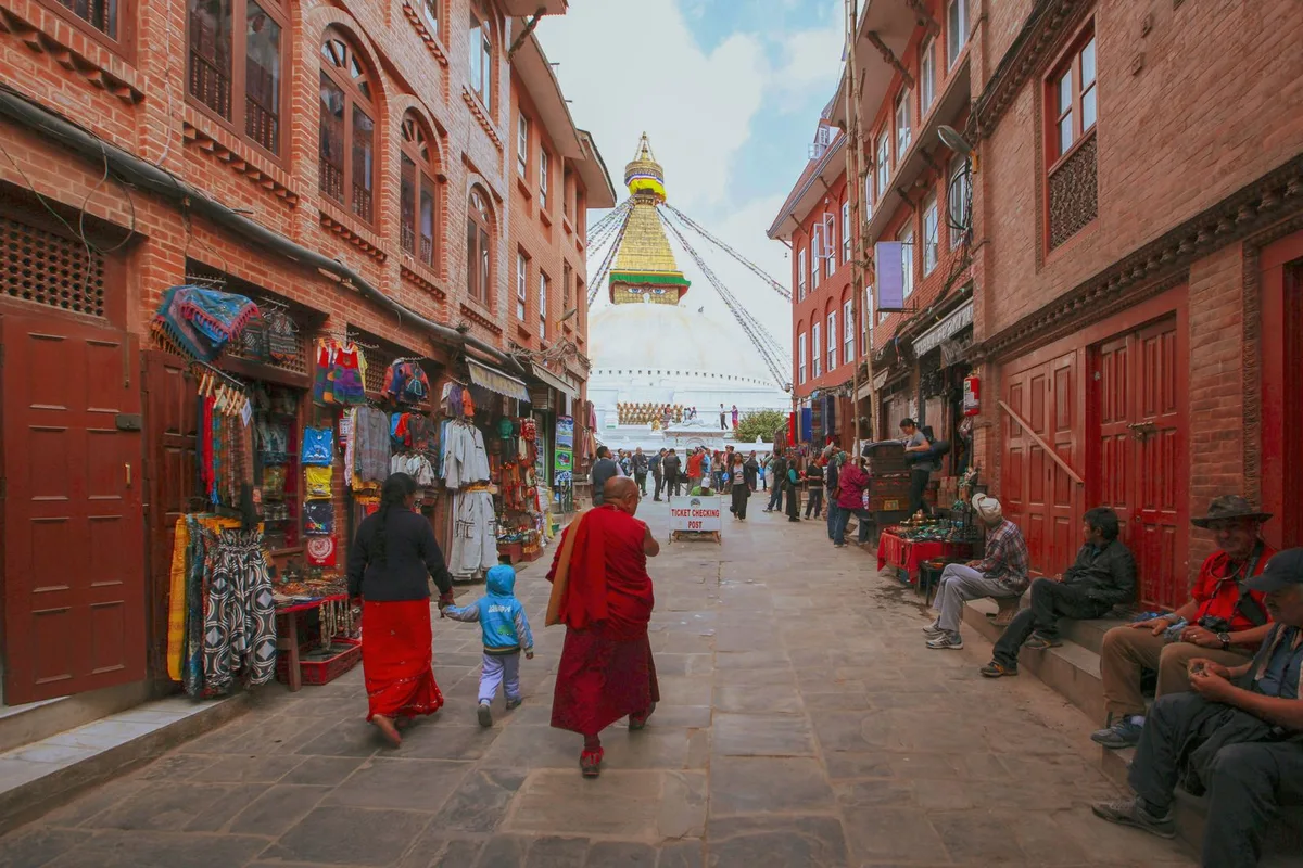 A brick lane of shops in Boudha leading towards the white dome of the stupa