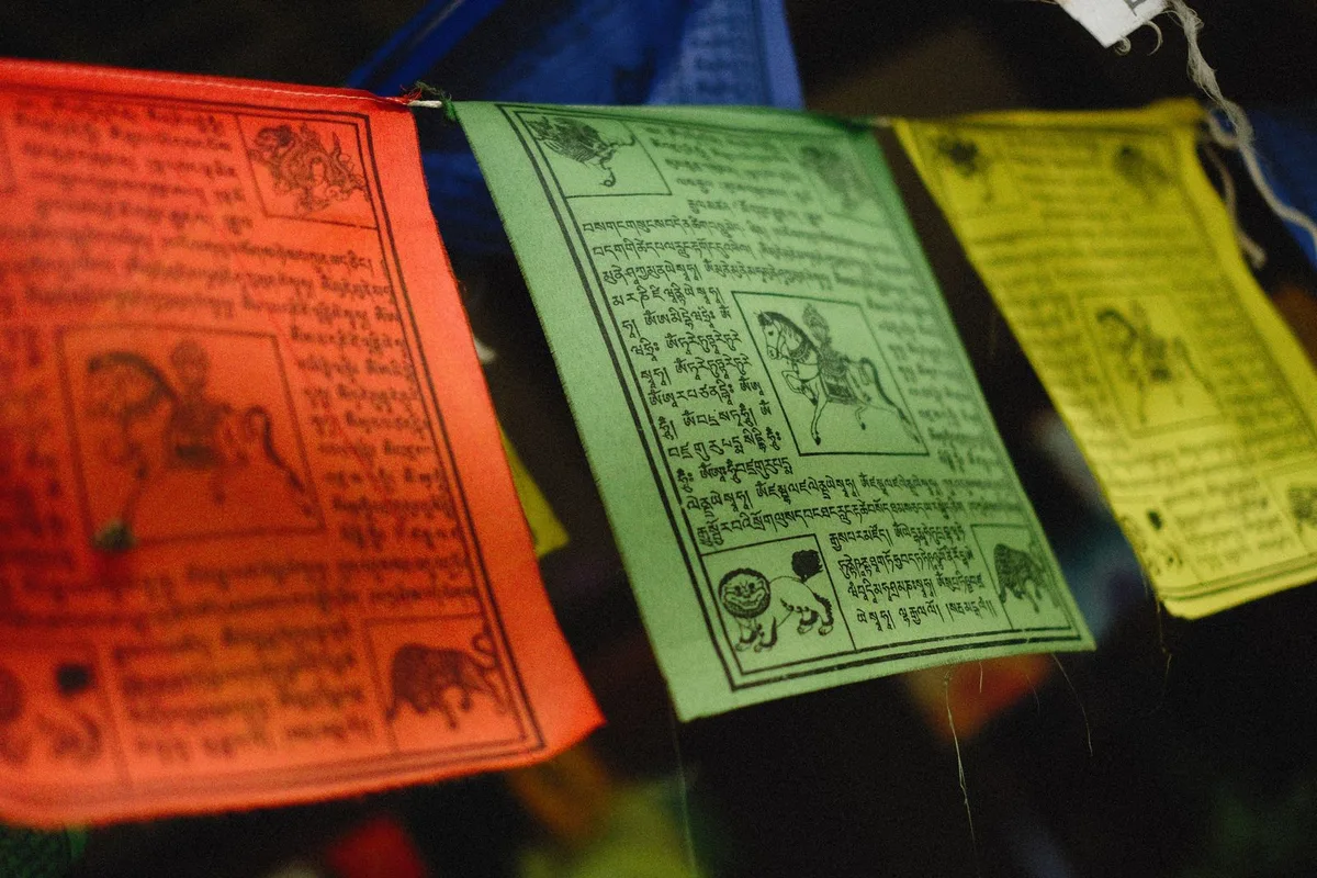 Printed prayer flags at a Kathmandu shrine, their mantras carried on the wind