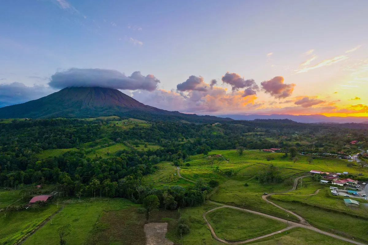 Arenal Volcano at sunset above the green plain of La Fortuna