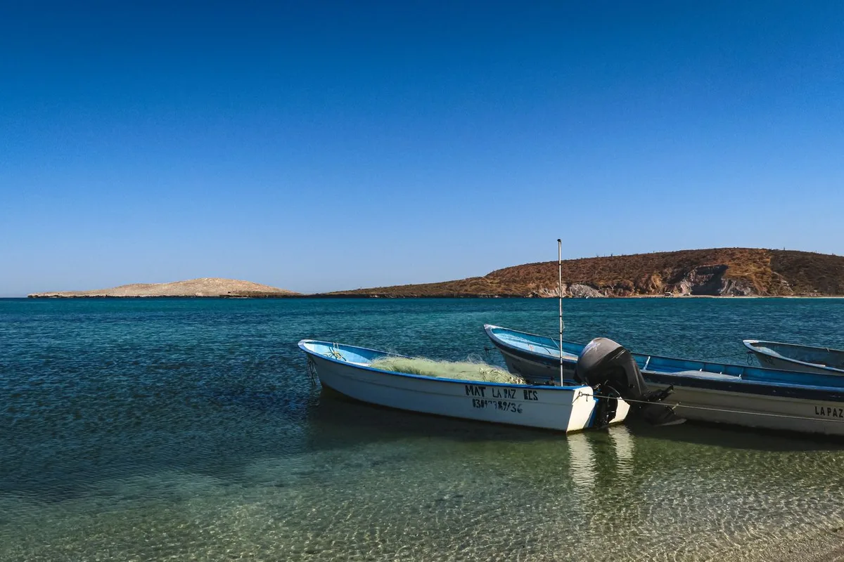 Two fishing pangas anchored in the turquoise shallows off the La Paz coast
