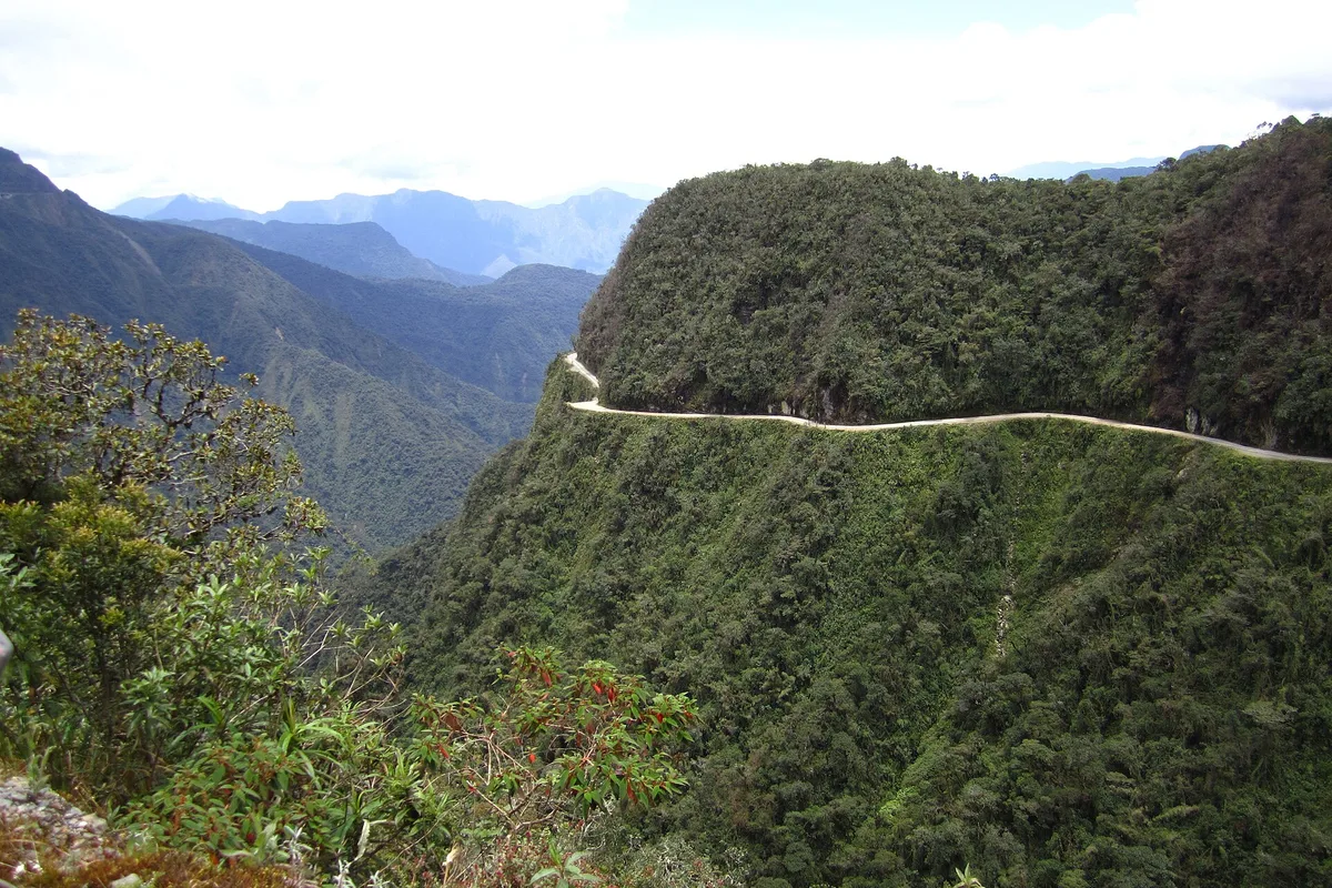 The Yungas Death Road carved along a green ridge above the valley