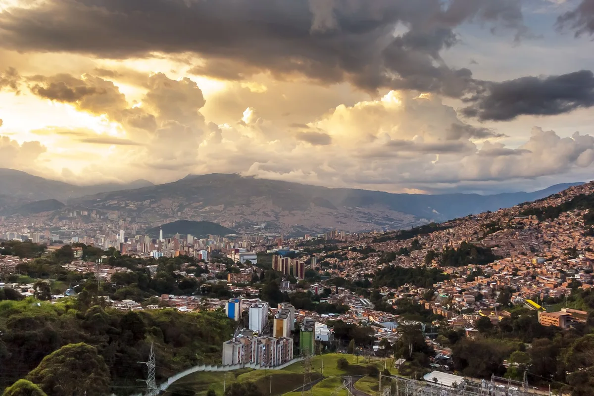The La Paz bowl at golden hour, the canyon city climbing its hillsides under storm light