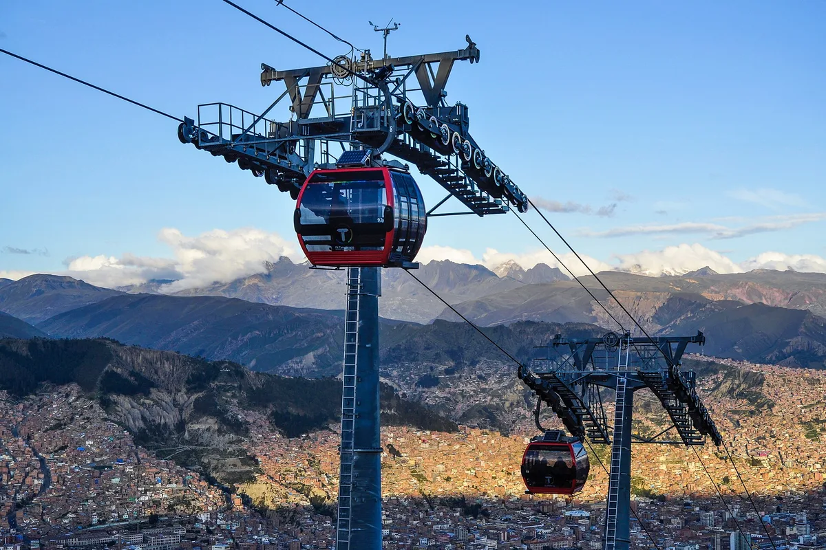 A red Mi Teleférico cabin crossing above the La Paz bowl