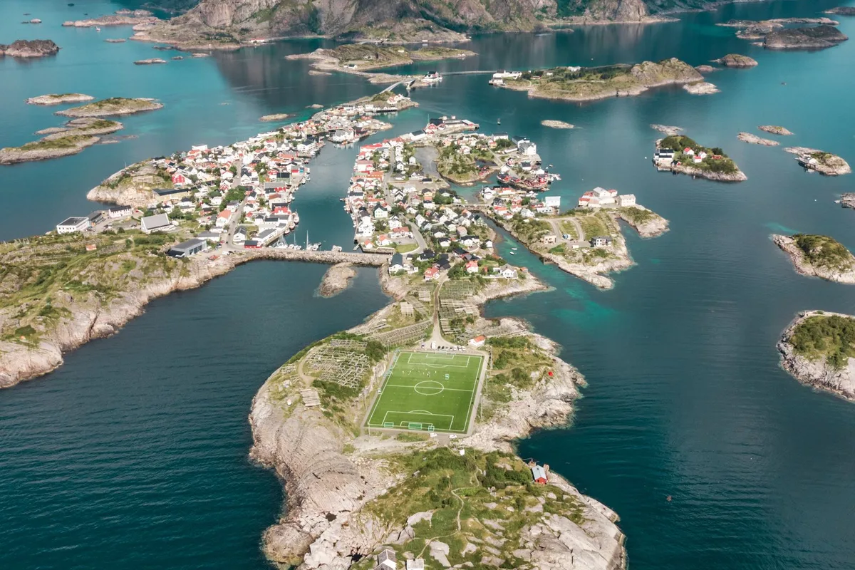 Henningsvær from the air — the village islets and the football pitch surrounded by sea