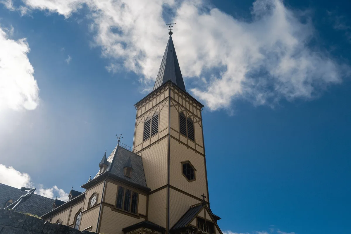 A wooden church tower in Lofoten against the sky