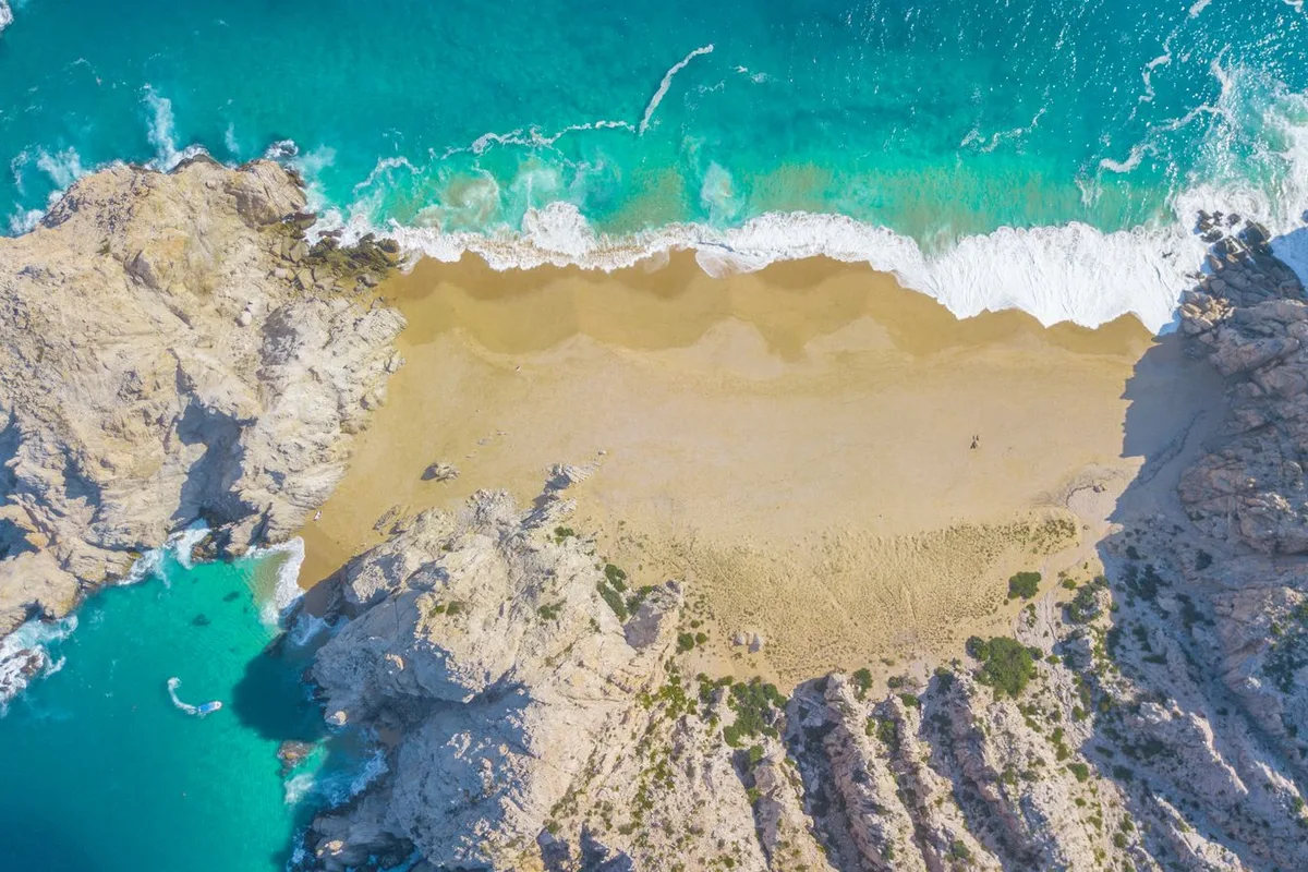 An aerial view of Divorce Beach, its pale cove between rocky headlands at Land's End